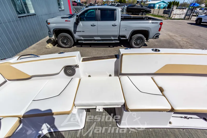 Slide: The Image of 2019 Glastron GTD 180 boat interior with beige seating, parked near a gray pickup truck. - 18