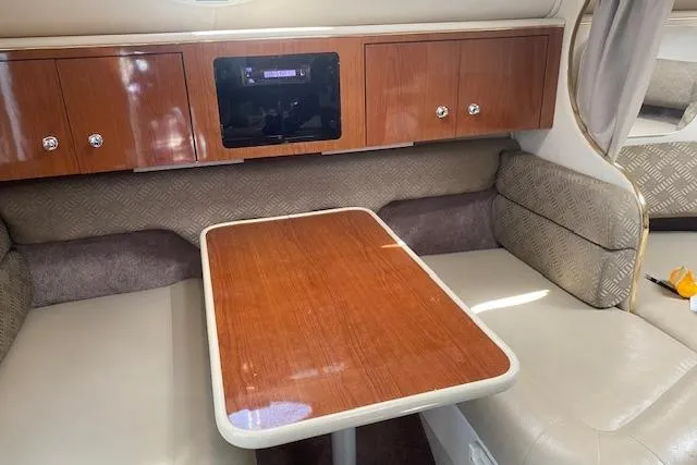 Slide: The Image of Interior of a 2001 Monterey 302 Cruiser with wood table and cushioned seating. - 19