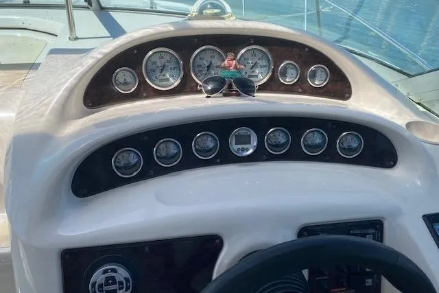 Slide: The Image of Dashboard of a 2001 Monterey 302 Cruiser boat with gauges and sunglasses. - 8