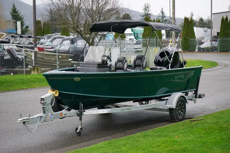 Slide: The Image of 2026 Lund 1800 Explorer Sport boat on trailer, parked outdoors. - 14