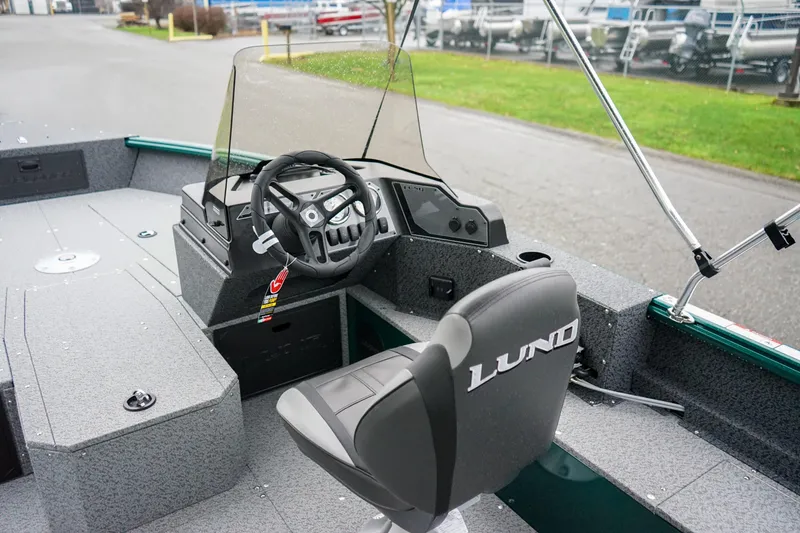 Slide: The Image of 2026 Lund 1800 Explorer Sport boat interior with steering wheel and seating. - 9