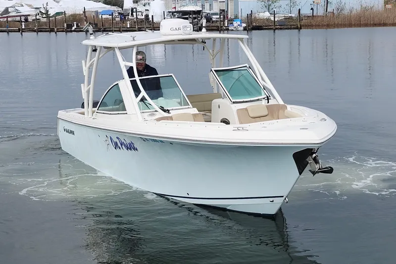 Slide: The Image of 2017 Sailfish 275 DC boat interior with seating, helm, and fishing rod holders. - 12