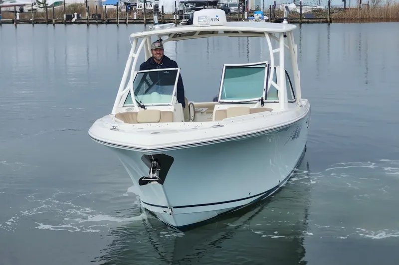 Slide: The Image of 2017 Sailfish 275 DC boat docked, featuring dual outboard engines and spacious seating. - 13