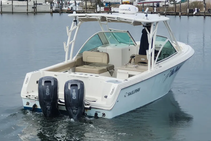 Slide: The Image of 2017 Sailfish 275 DC boat interior with beige seating and a small sink area. - 21