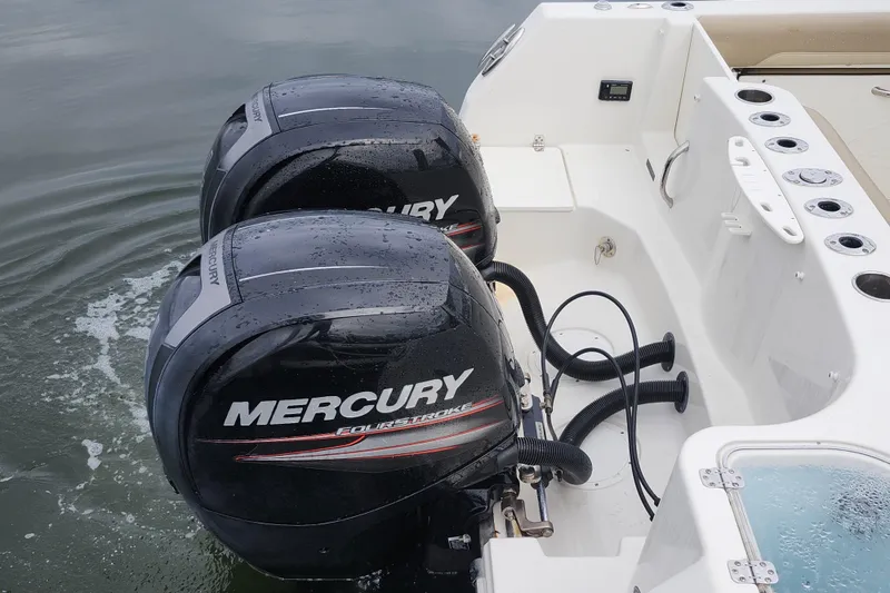 Slide: The Image of Twin Mercury outboard engines on a 2017 Sailfish 275 DC boat, docked on calm water. - 27