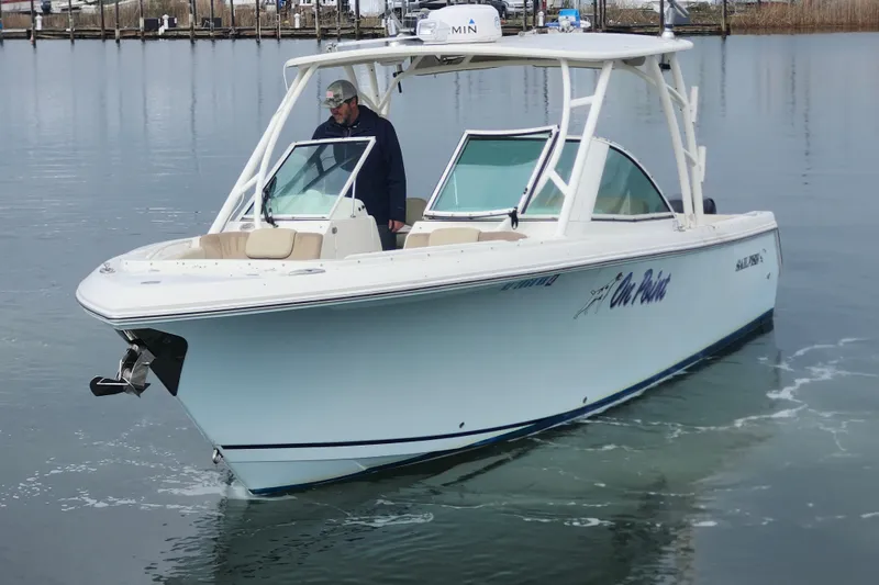 Slide: The Image of 2017 Sailfish 275 DC boat cruising on calm water with a person onboard. - 4