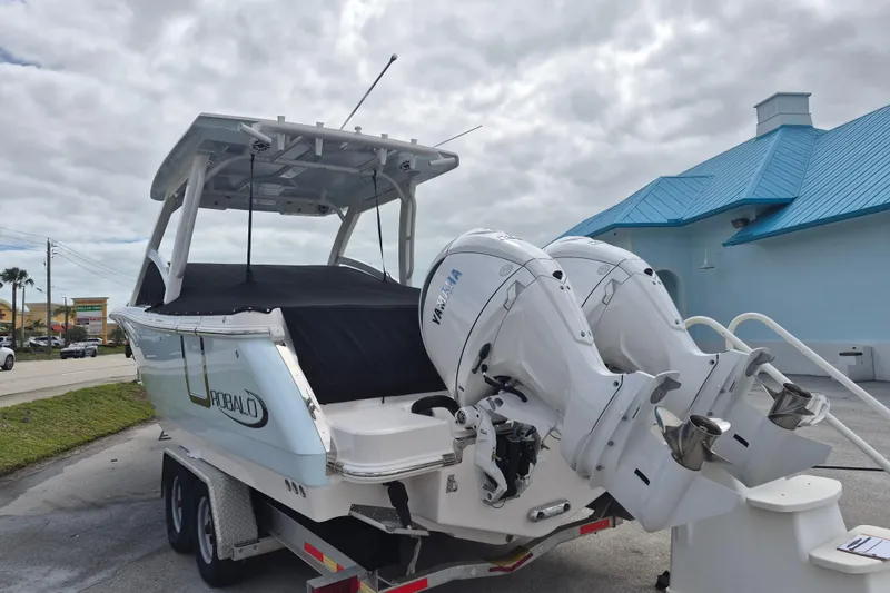 Slide: The Image of 2026 Robalo R277 Dual Console boat with twin Yamaha outboard engines on a trailer. - 13