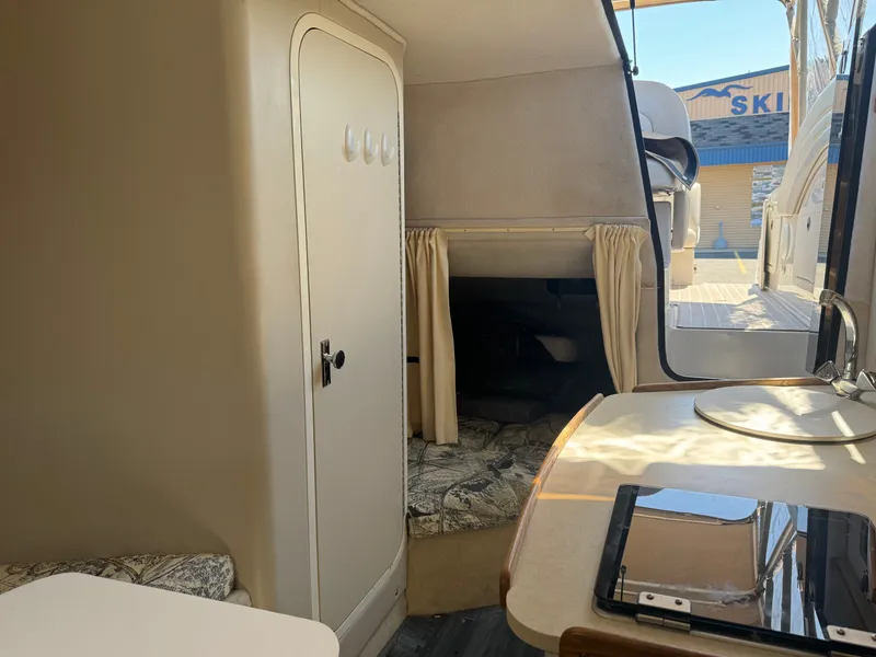 Slide: The Image of Interior of 1999 Four Winns 258 Vista yacht, featuring table and seating area. - 10