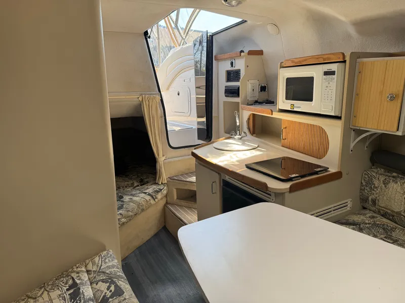 Slide: The Image of Interior of a 1999 Four Winns 258 Vista yacht with kitchen and seating area. - 11