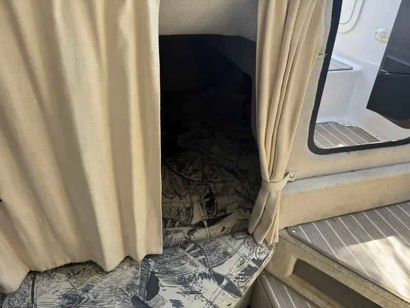 Slide: The Image of Interior of 1999 Four Winns 258 Vista with curtain and seating area. - 13