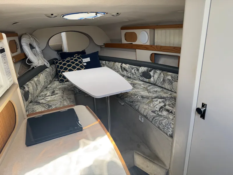 Slide: The Image of Interior of a 1999 Four Winns 258 Vista yacht with table and seating area. - 6