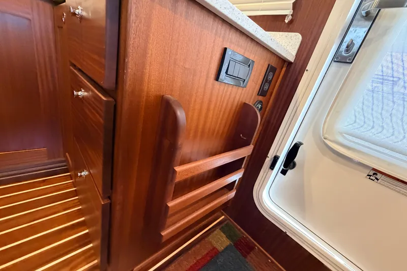 Slide: The Image of Interior of 2022 American Tug 365, featuring wooden cabinetry and a white door. - 17