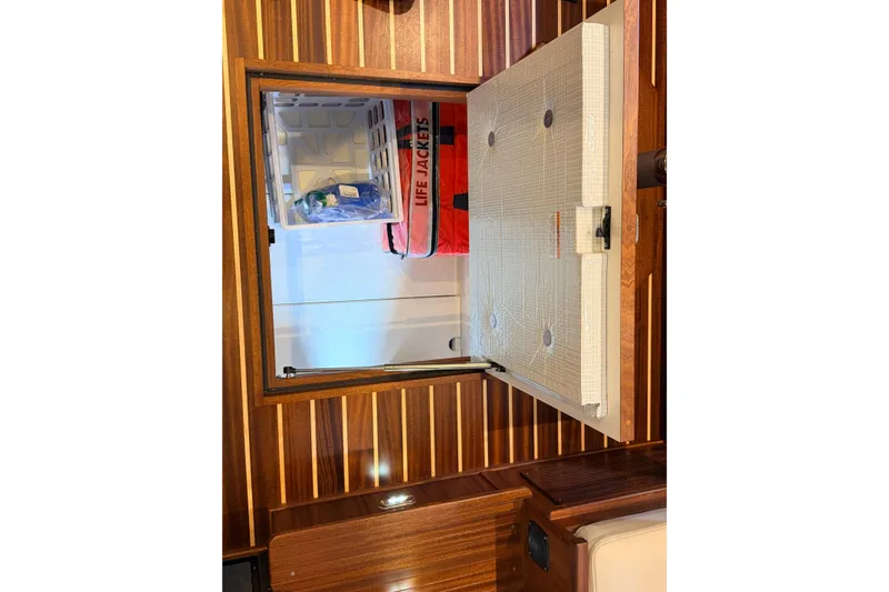 Slide: The Image of Storage compartment in 2022 American Tug 365, featuring life jackets and wooden interior. - 20