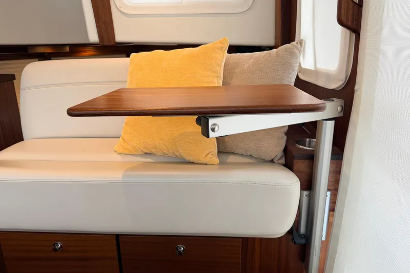Slide: The Image of Interior of 2022 American Tug 365 with a foldable wooden table and cozy cushions. - 29