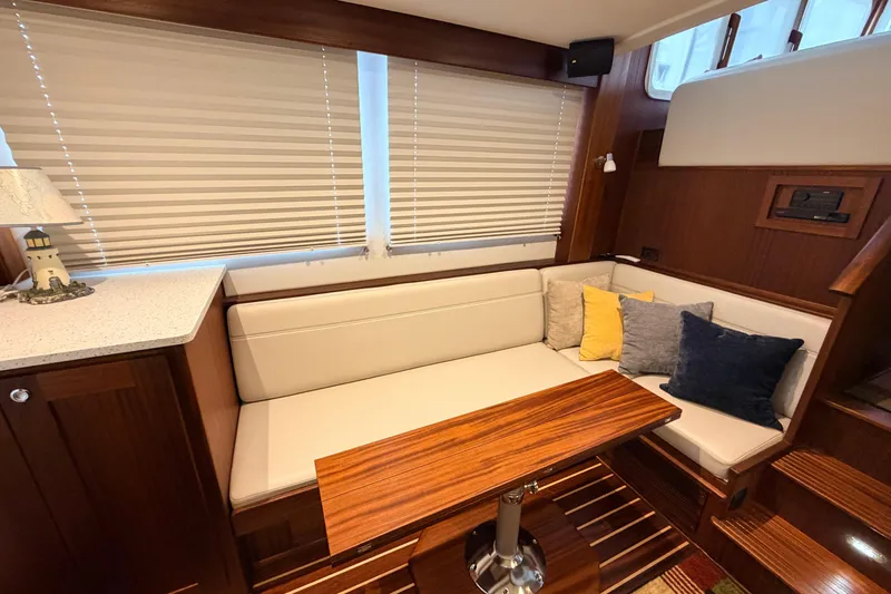 Slide: The Image of Interior of 2022 American Tug 365 with cozy seating and wooden table. - 3