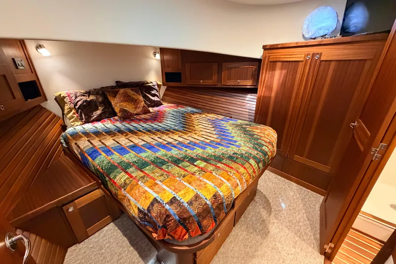 Slide: The Image of Cozy cabin interior of 2022 American Tug 365 with colorful bedding and wooden cabinetry. - 52