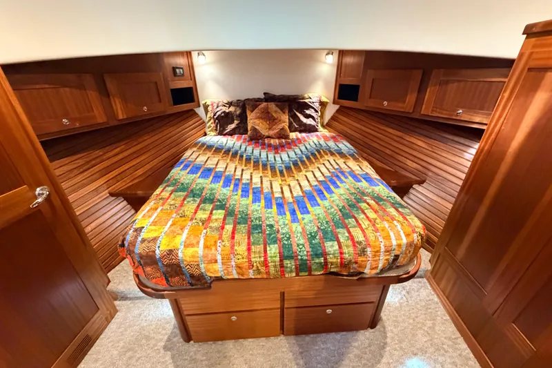 Slide: The Image of Cozy cabin interior of 2022 American Tug 365 with colorful bedding and wooden cabinetry. - 53