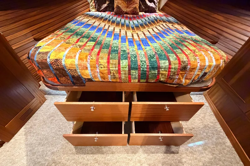 Slide: The Image of Cozy cabin interior of 2022 American Tug 365 with colorful quilt and open storage drawers. - 54