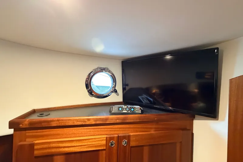 Slide: The Image of Interior of 2022 American Tug 365 with TV, remote, and porthole window. - 55