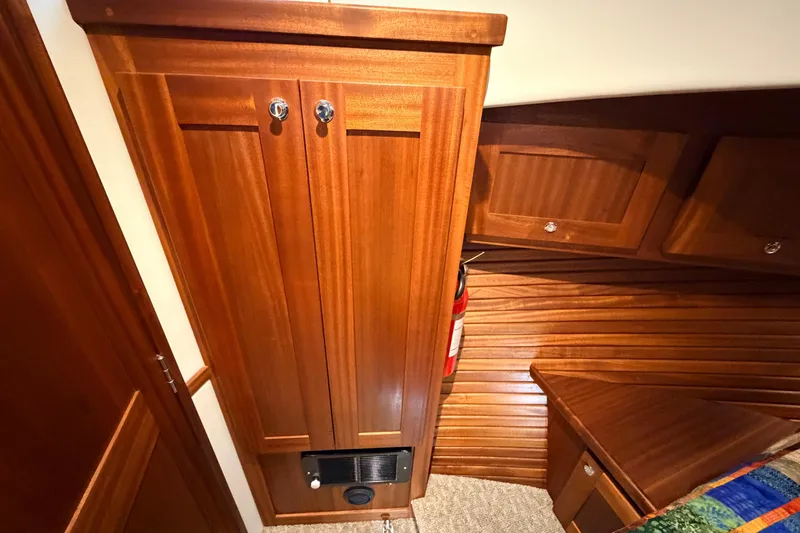Slide: The Image of Wooden interior of 2022 American Tug 365, featuring cabinetry and a fire extinguisher. - 57