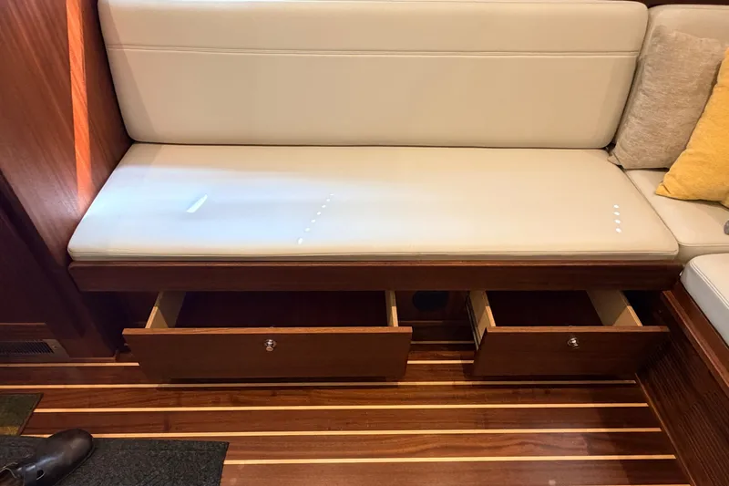 Slide: The Image of Interior of 2022 American Tug 365 with white cushioned seating and open wooden storage drawers. - 6