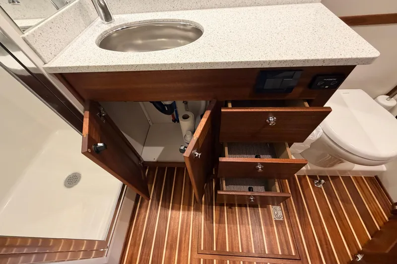 Slide: The Image of Luxurious 2022 American Tug 365 bathroom with wood cabinetry, sink, and striped flooring. - 66
