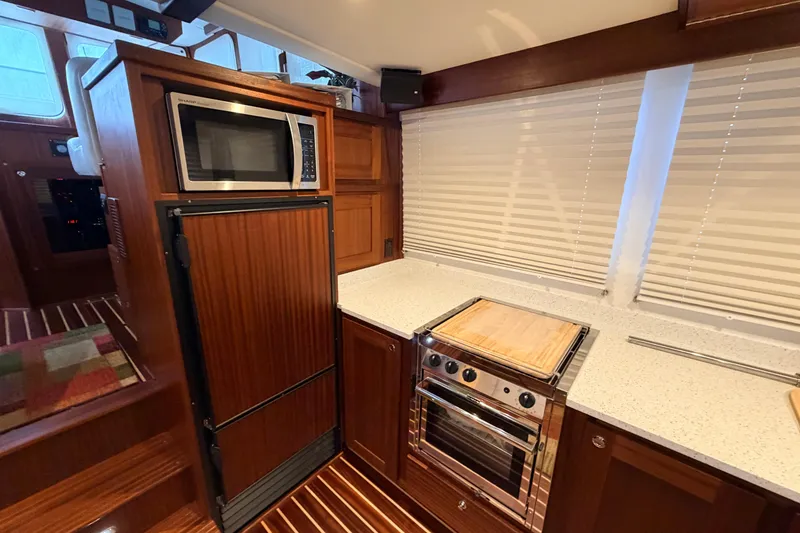 Slide: The Image of 2022 American Tug 365 kitchen with microwave, oven, and wooden cabinetry. - 8