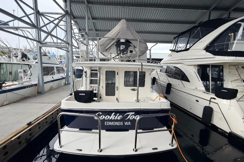 Slide: The Image of American Tug 365, 2022 model, docked in a marina with other boats. - 80