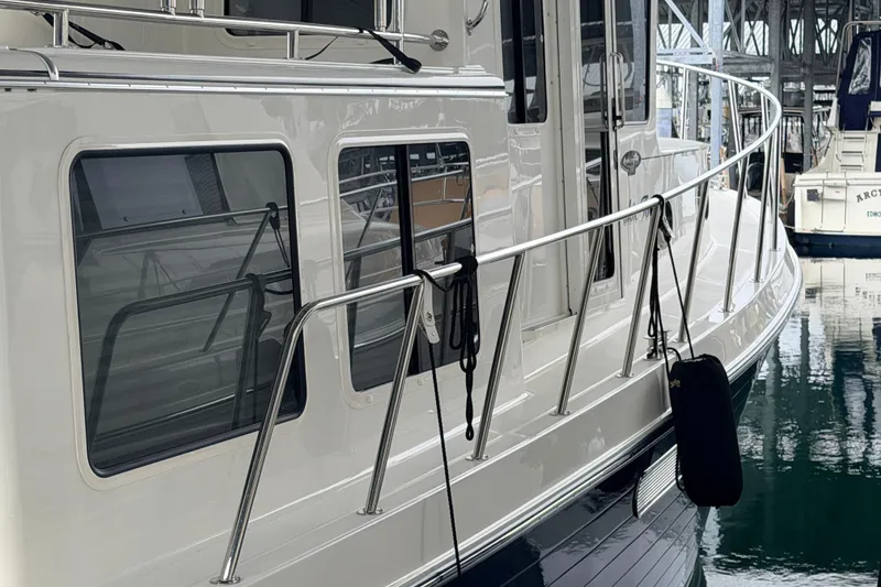 Slide: The Image of 2022 American Tug 365 yacht docked, showcasing sleek design and polished railings. - 82