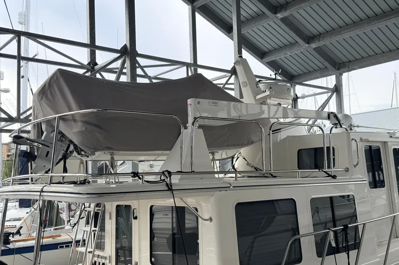 Slide: The Image of 2022 American Tug 365 yacht with covered equipment on deck, docked in a marina. - 84