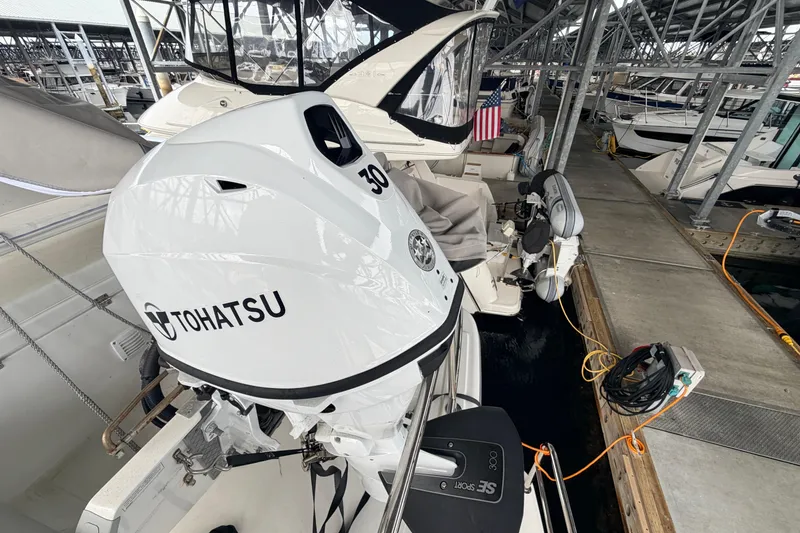 Slide: The Image of American Tug 365 (2022) docked with Tohatsu outboard motor in marina setting. - 91