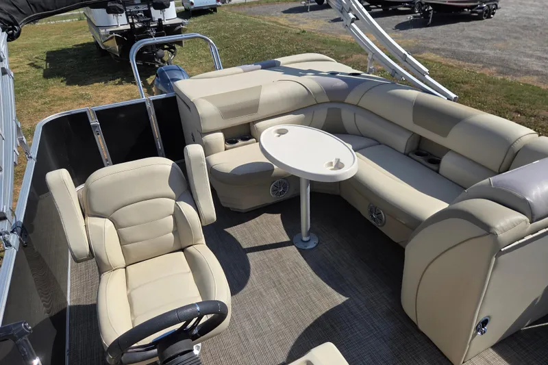 Slide: The Image of 2019 Starcraft EX 20 CF pontoon boat interior with beige seating and table. - 17