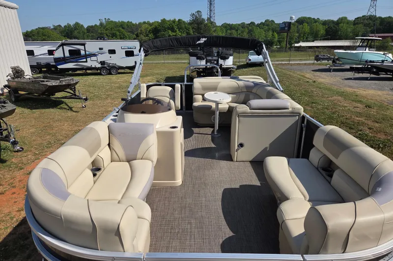 Slide: The Image of 2019 Starcraft EX 20 CF pontoon boat with beige seating, parked outdoors. - 18