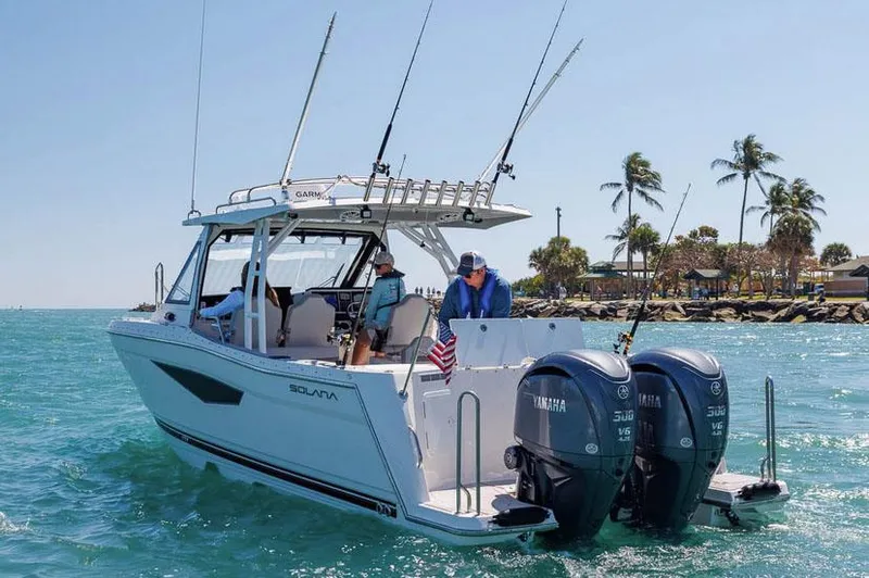 Slide: The Image of Manufacturer Provided Image: 2025 Solara S-310 CW boat on water, featuring dual Yamaha engines, palm trees in background. - 2