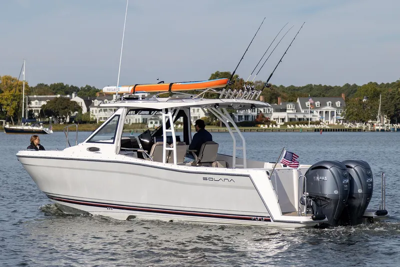 Slide: The Image of Manufacturer Provided Image: 2025 Solara S-310 CW boat cruising on a scenic lake with fishing rods. - 8