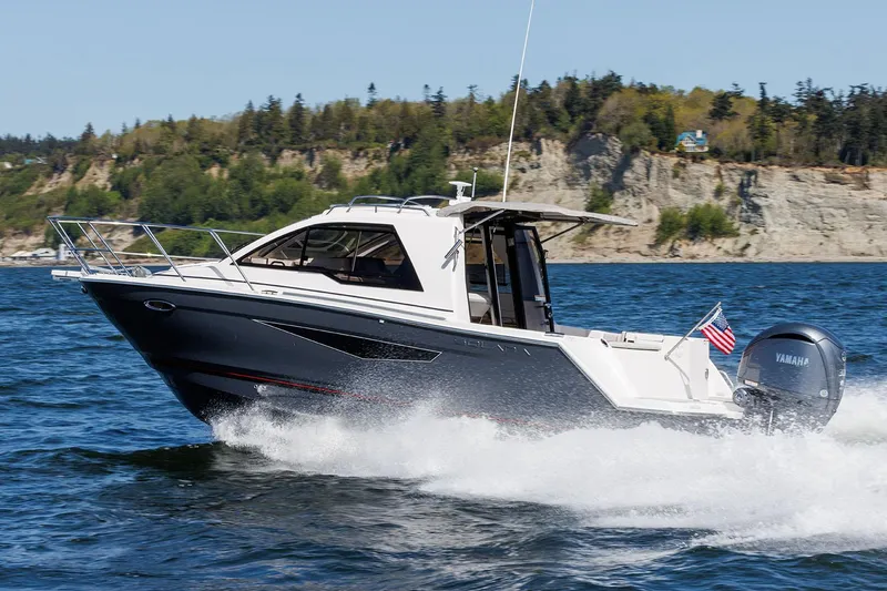 Slide: The Image of Manufacturer Provided Image: 2025 Solara S-250 Coupe cruising on a scenic lake with rocky shoreline. - 3