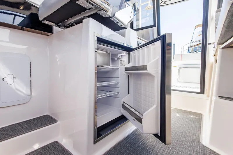 Slide: The Image of Manufacturer Provided Image: 2025 Solara S-250 Coupe interior with open mini fridge, showcasing modern design. - 14