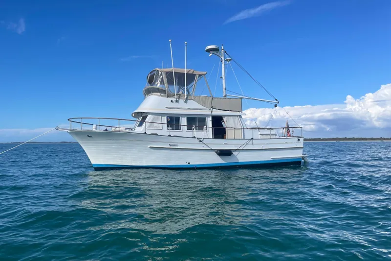 The Image of 1987 Albin 36 Trawler anchored on calm blue waters under a clear sky. - 0