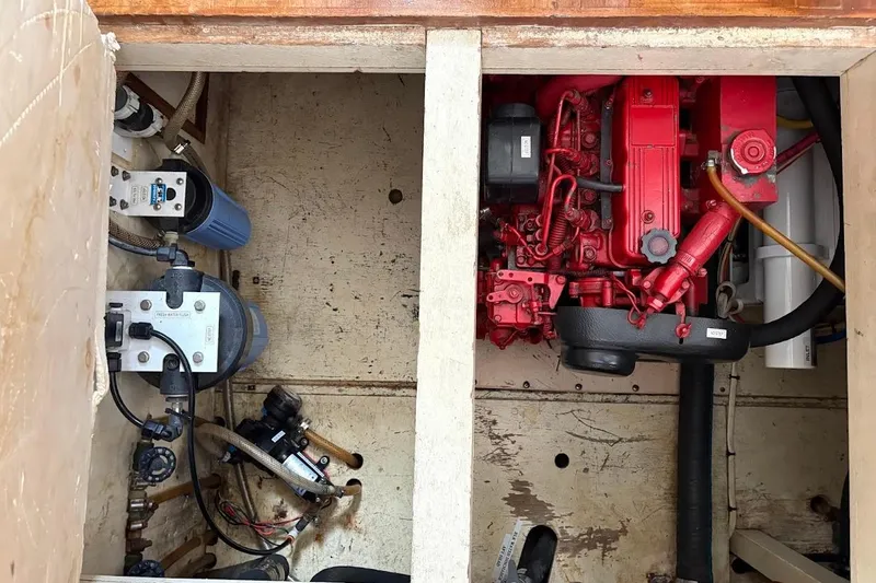 Slide: The Image of Engine compartment of a 1987 Albin 36 Trawler, featuring red engine and mechanical components. - 23