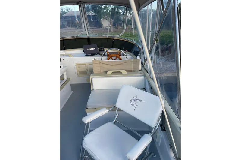 Slide: The Image of 1987 Albin 36 Trawler interior with helm, wooden wheel, and cushioned seating. - 29