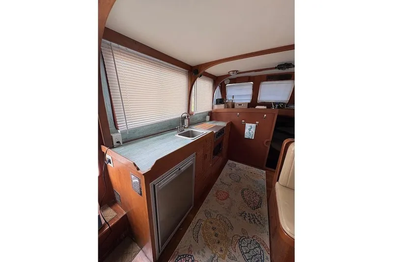 Slide: The Image of Interior of 1987 Albin 36 Trawler with wooden cabinetry and compact kitchen area. - 5