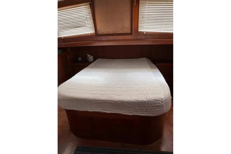 Slide: The Image of Cozy cabin bedroom in 1987 Albin 36 Trawler with wooden interior and white bedding. - 7