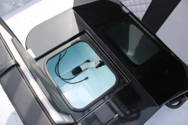 Slide: The Image of Livewell compartment in 2026 Freedom Boats 21' Commander, featuring a pump and black lid. - 17