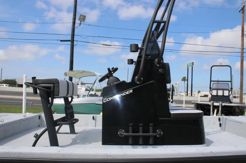 Slide: The Image of 2026 Freedom Boats 21' Commander with sleek black console and seating, under a clear blue sky. - 4