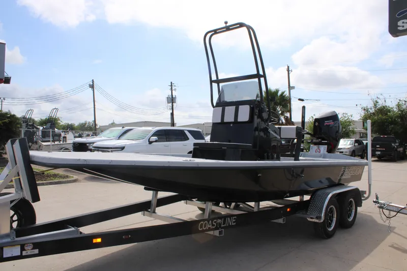 Slide: The Image of 2026 Freedom Boats 21' Commander on trailer, parked outdoors under a partly cloudy sky. - 6