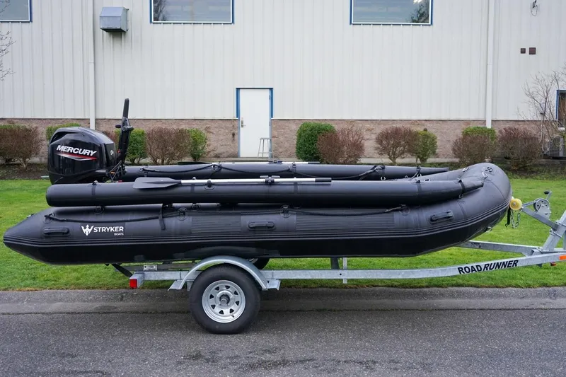 Slide: The Image of 2025 Stryker Tunnel JET PRO 470 inflatable boat on trailer, parked outdoors. - 3