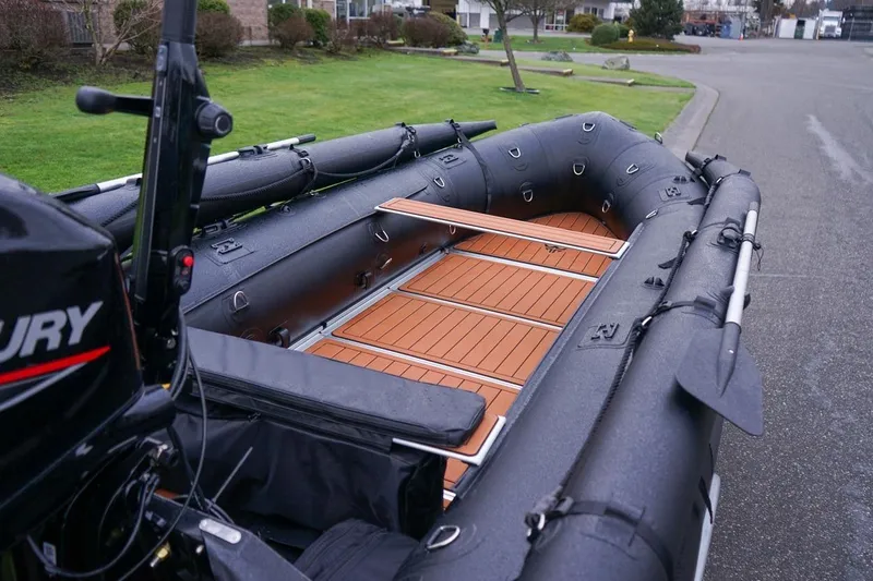 Slide: The Image of 2025 Stryker Tunnel JET PRO 470 inflatable boat with wooden deck and Mercury engine. - 6