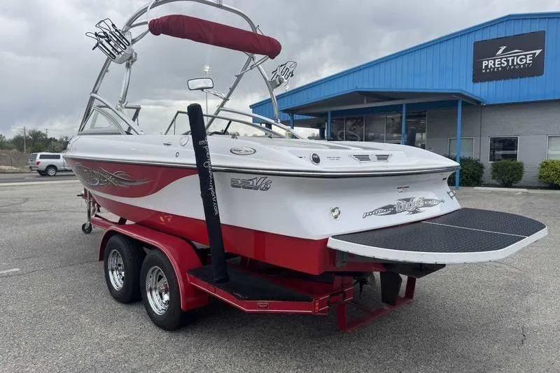 Slide: The Image of 2006 Tigé 22Ve boat on trailer, red and white, parked outside Prestige Water Sports. - 10