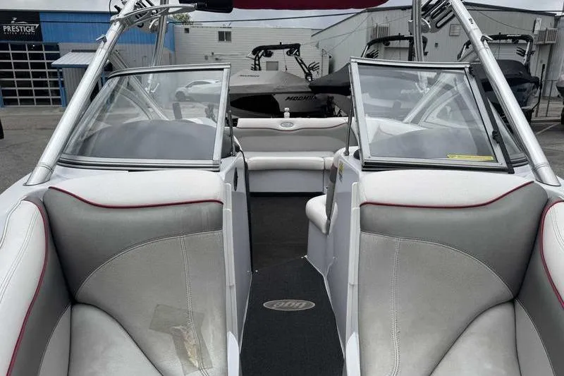 Slide: The Image of 2006 Tigé 22Ve boat interior with gray and white seating, open windshield, and visible dashboard. - 15