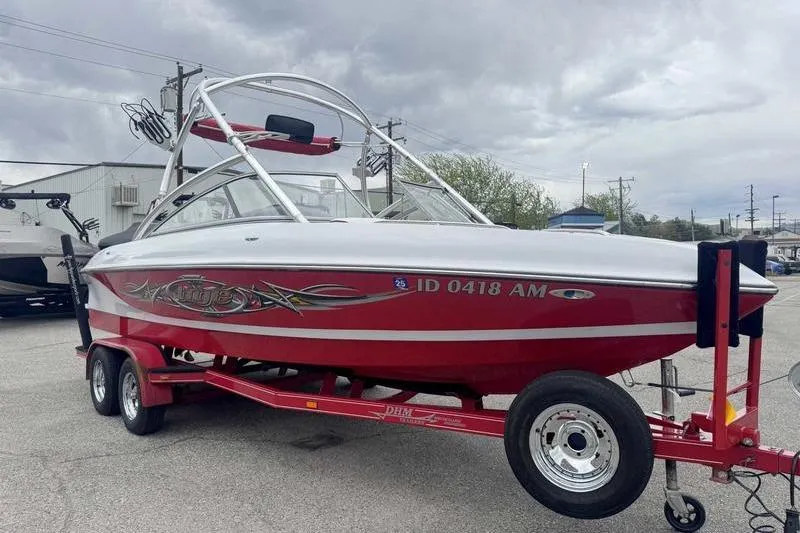 Slide: The Image of 2006 Tigé 22Ve boat on trailer, red and white design, parked outdoors. - 7